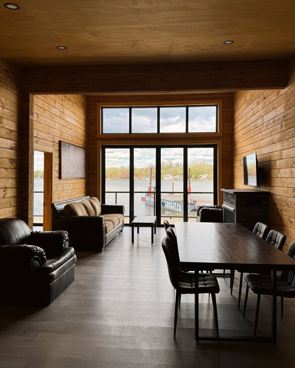 Timber living and dining space opening toward the water