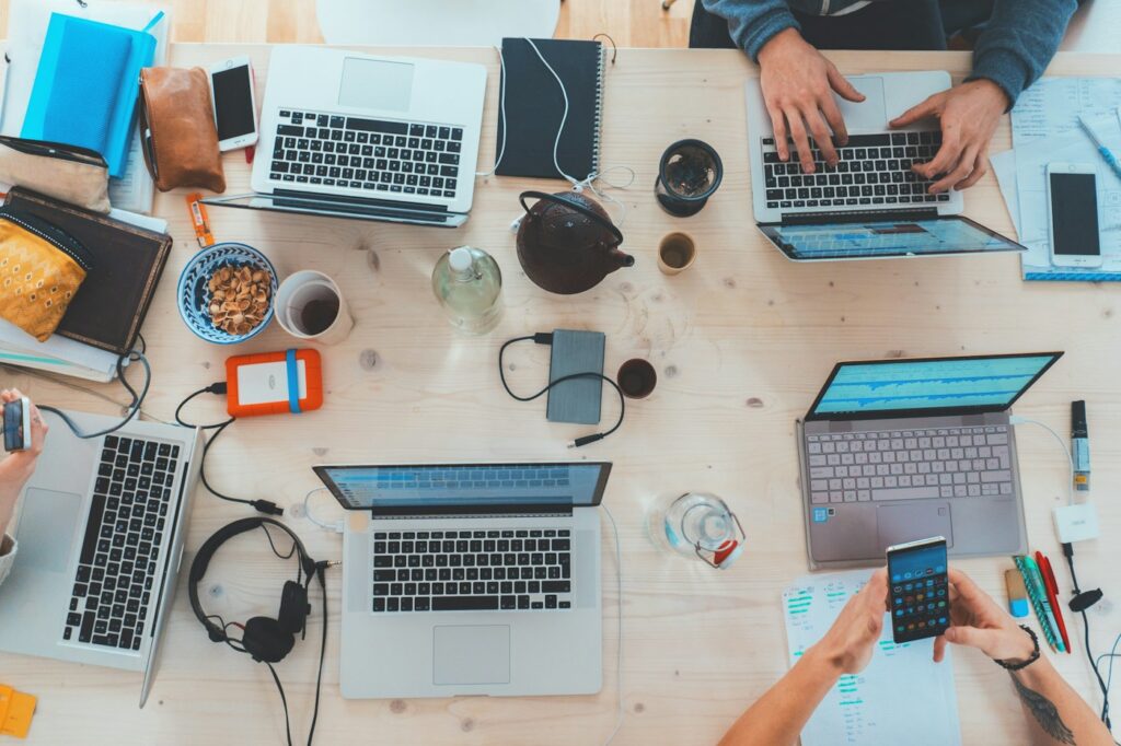 People collaborating with laptops around a work table for small business website planning
